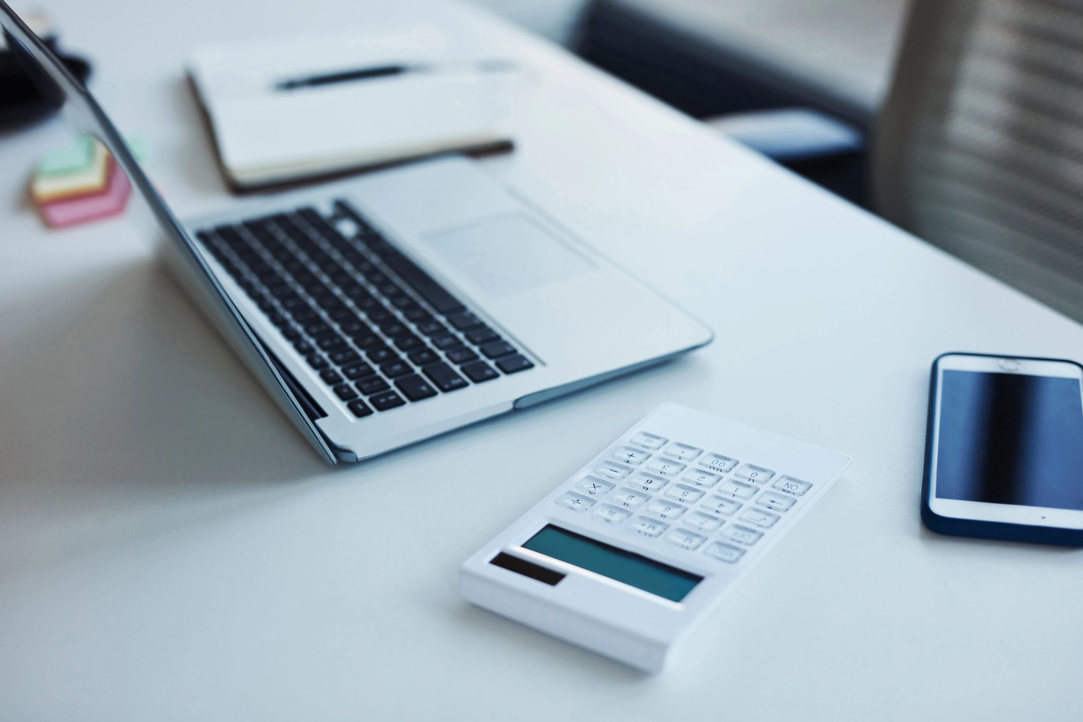 Calculator and laptop on an office desk
